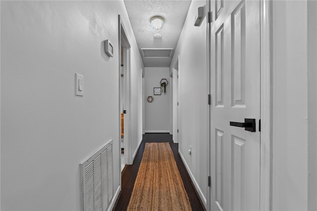 hallway with dark wood-type flooring and a textured ceiling