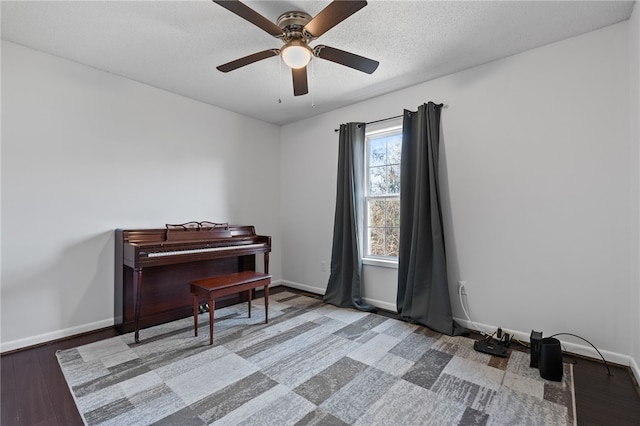 miscellaneous room with ceiling fan, wood-type flooring, and a textured ceiling