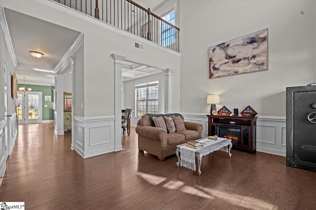 living room featuring decorative columns, coffered ceiling, crown molding, beamed ceiling, and dark hardwood / wood-style floors