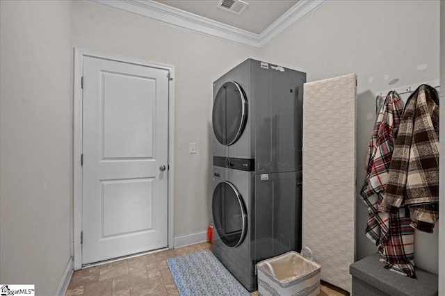 washroom featuring stacked washer and dryer and ornamental molding