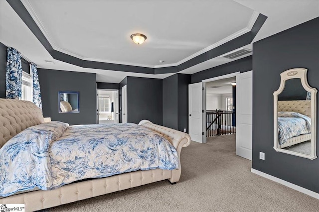 bedroom with a tray ceiling, crown molding, and carpet floors