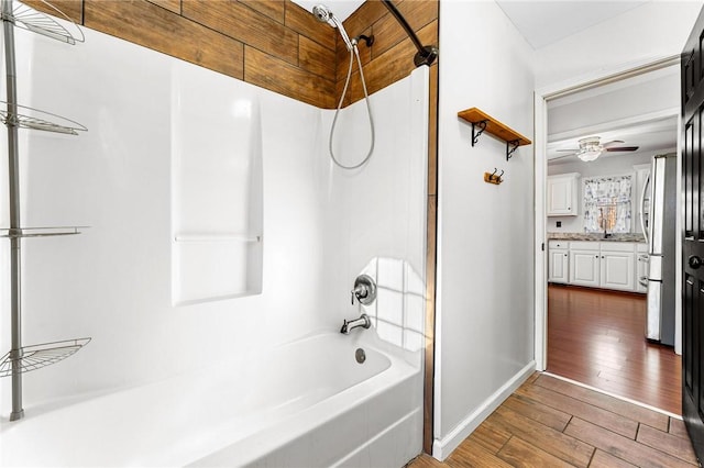 bathroom with vanity, hardwood / wood-style floors, shower / bathtub combination, and ceiling fan