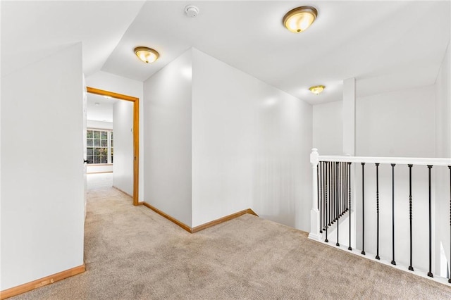 hall featuring light colored carpet and lofted ceiling