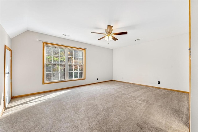 carpeted spare room featuring vaulted ceiling and ceiling fan