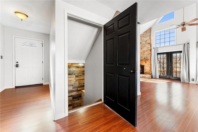 foyer with wood-type flooring, high vaulted ceiling, french doors, and ceiling fan