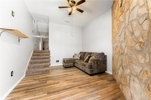 living room featuring ceiling fan, lofted ceiling, and light wood-type flooring