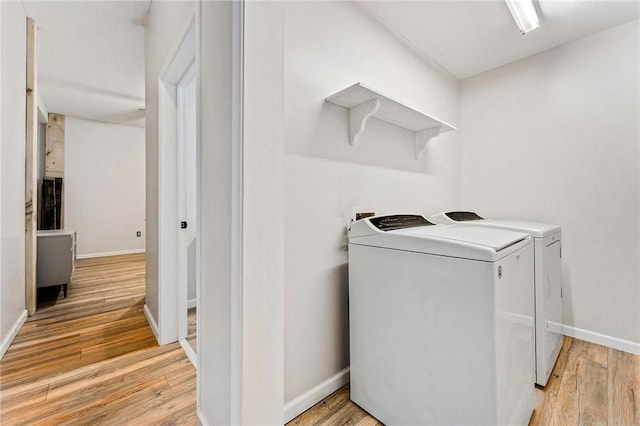 laundry area featuring washer and dryer and light hardwood / wood-style floors