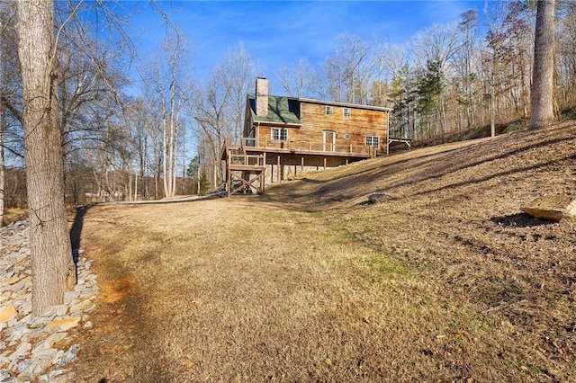 rear view of house with a lawn and a deck