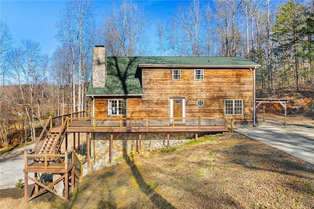 rear view of property featuring a yard and a deck