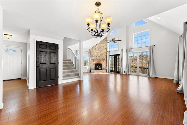 unfurnished living room with hardwood / wood-style flooring, a stone fireplace, a healthy amount of sunlight, and high vaulted ceiling