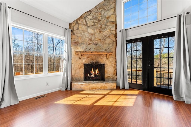 unfurnished living room with hardwood / wood-style flooring, a healthy amount of sunlight, and french doors