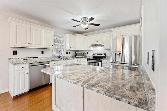 kitchen featuring white cabinetry, appliances with stainless steel finishes, light stone counters, and light hardwood / wood-style flooring