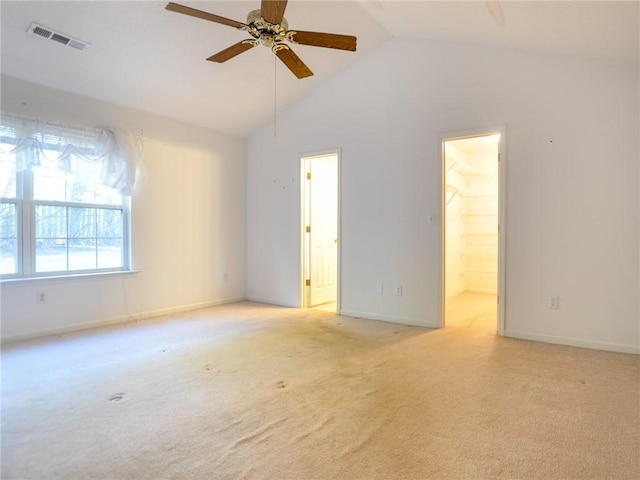 spare room featuring ceiling fan, lofted ceiling, and light carpet