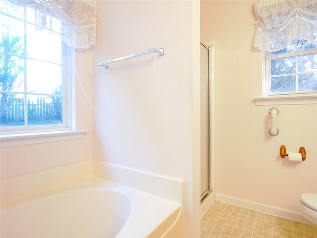 bathroom with a healthy amount of sunlight, toilet, and separate shower and tub