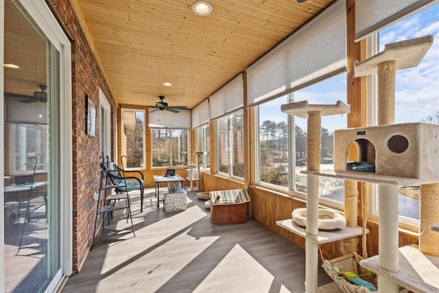 sunroom / solarium featuring ceiling fan and wooden ceiling