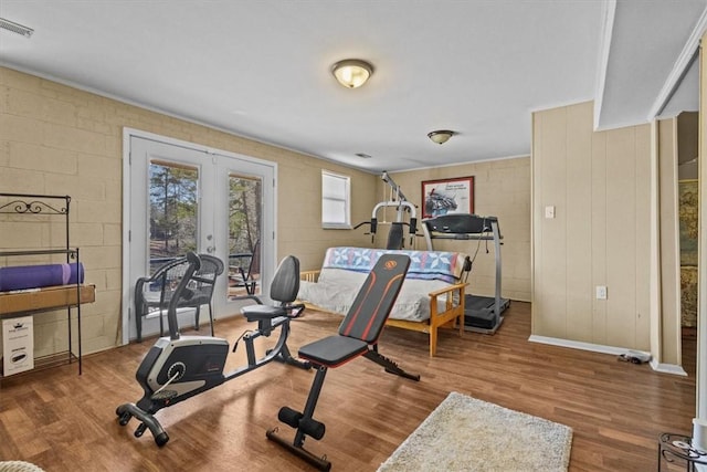 workout room with wood-type flooring and french doors