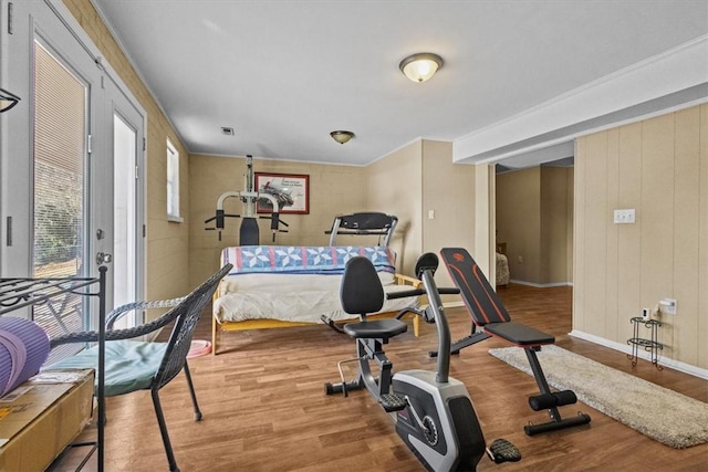 workout area featuring light hardwood / wood-style flooring and wooden walls