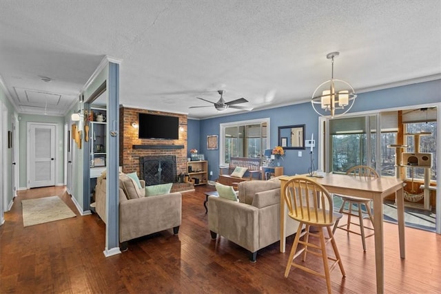 living room featuring ceiling fan with notable chandelier, a textured ceiling, dark hardwood / wood-style flooring, and ornamental molding