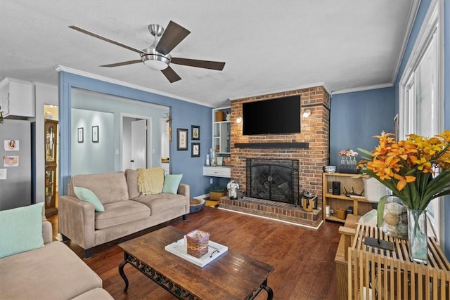 living room with ceiling fan, a brick fireplace, dark hardwood / wood-style flooring, and ornamental molding