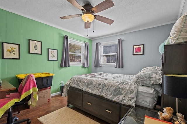 bedroom with a textured ceiling, ceiling fan, ornamental molding, and dark wood-type flooring