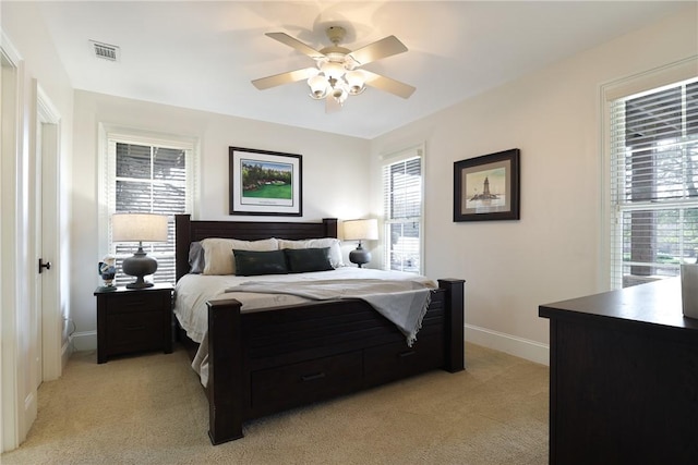 bedroom with ceiling fan and light carpet