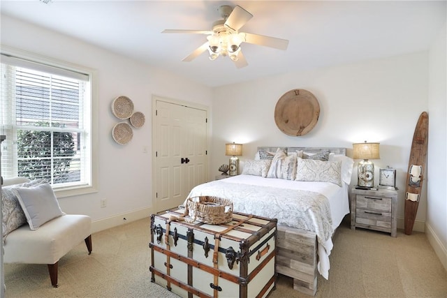 carpeted bedroom featuring ceiling fan and a closet