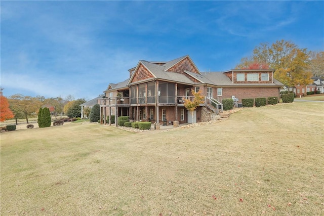 back of property featuring a lawn, a wooden deck, and a sunroom