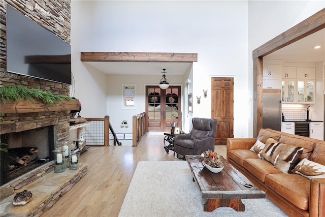 living room featuring wine cooler, a fireplace, and light wood-type flooring