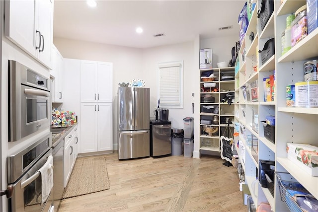 interior space with white cabinetry, light hardwood / wood-style flooring, and stainless steel appliances