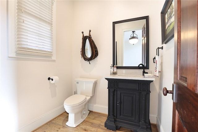 bathroom featuring vanity, wood-type flooring, and toilet