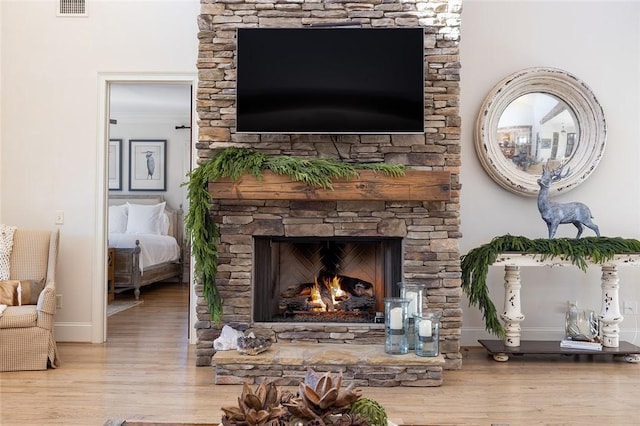 room details featuring hardwood / wood-style floors and a stone fireplace