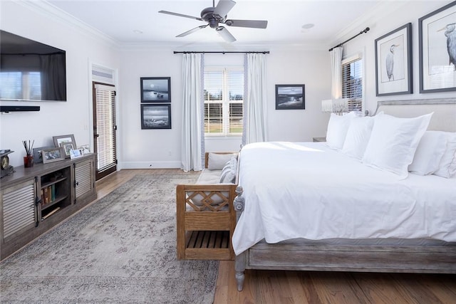 bedroom featuring ceiling fan, light wood-type flooring, and crown molding