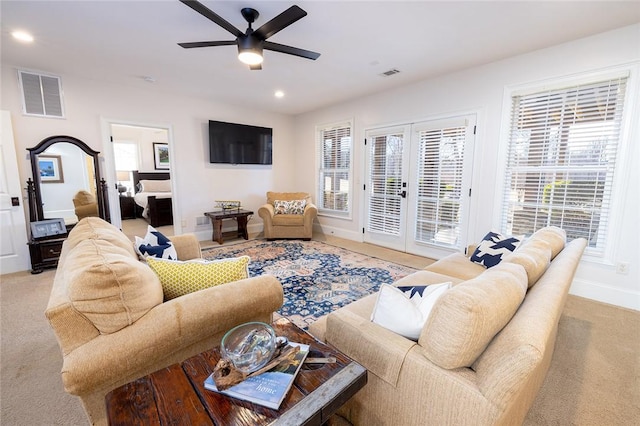 living room featuring french doors, light colored carpet, and ceiling fan