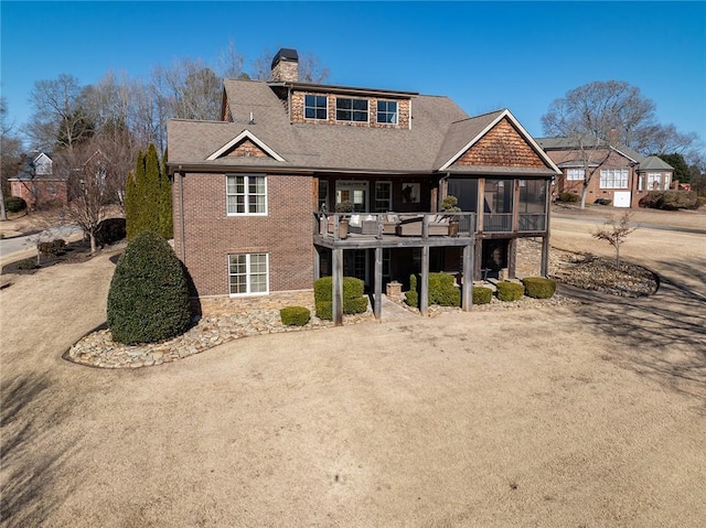 back of property featuring a wooden deck and a sunroom