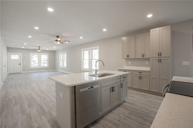 kitchen featuring stainless steel dishwasher, gray cabinetry, light wood-type flooring, and sink