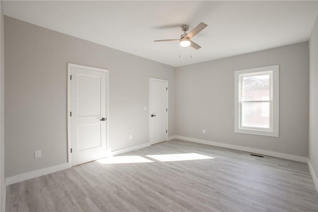 empty room with ceiling fan and light hardwood / wood-style flooring