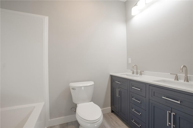 bathroom with hardwood / wood-style floors, vanity, and toilet