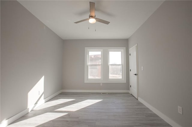 empty room with ceiling fan and light hardwood / wood-style floors