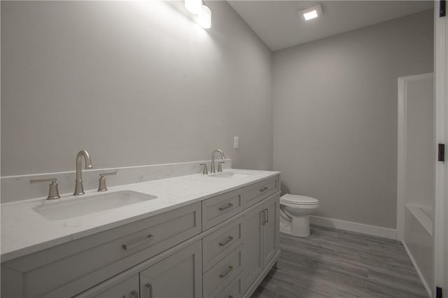 bathroom with hardwood / wood-style floors, vanity, and toilet