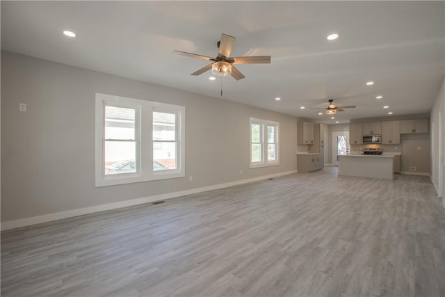 unfurnished living room with ceiling fan and light hardwood / wood-style floors