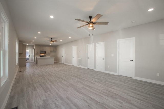 unfurnished living room featuring ceiling fan and light hardwood / wood-style floors