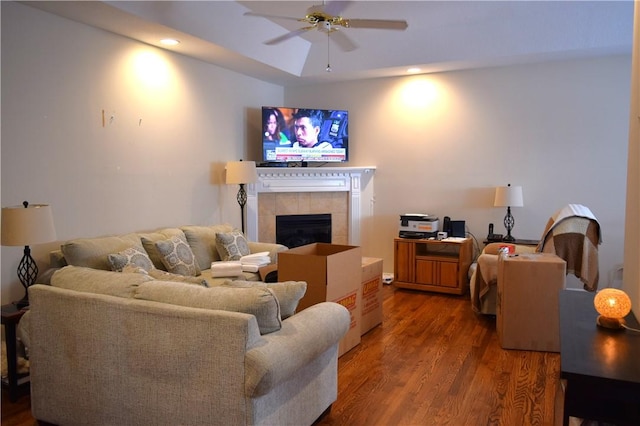 living room featuring ceiling fan, hardwood / wood-style floors, and a fireplace