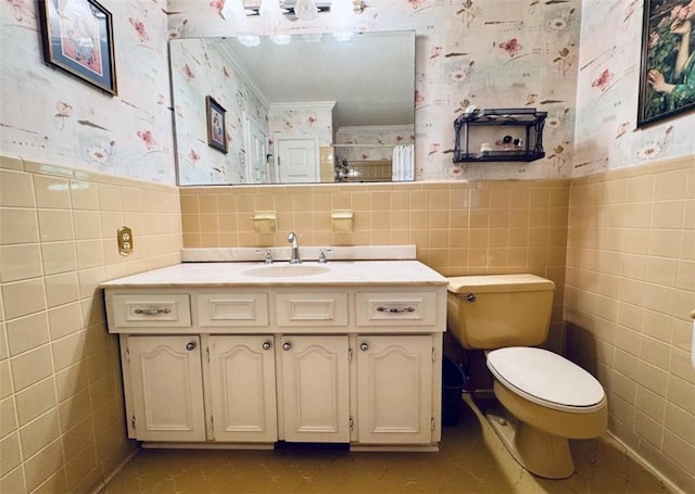 bathroom with vanity, toilet, tile walls, and ornamental molding