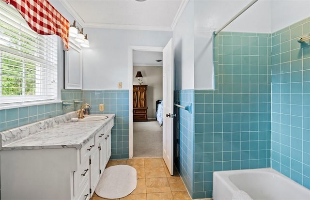 bathroom featuring washtub / shower combination, tile patterned flooring, vanity, tile walls, and ornamental molding