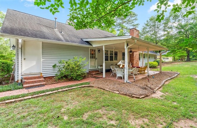 back of property with a yard and a patio