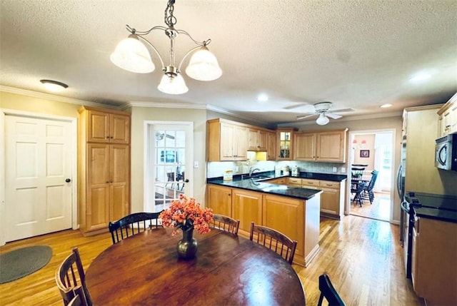 dining area featuring crown molding, sink, and light hardwood / wood-style floors