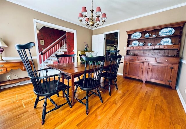 dining space with a notable chandelier, crown molding, and light hardwood / wood-style flooring