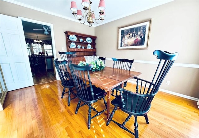 dining space with hardwood / wood-style flooring, crown molding, and a notable chandelier