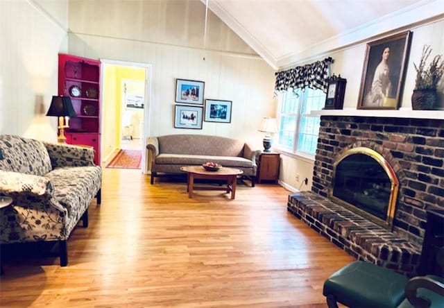 living room featuring a brick fireplace, crown molding, lofted ceiling, and hardwood / wood-style floors