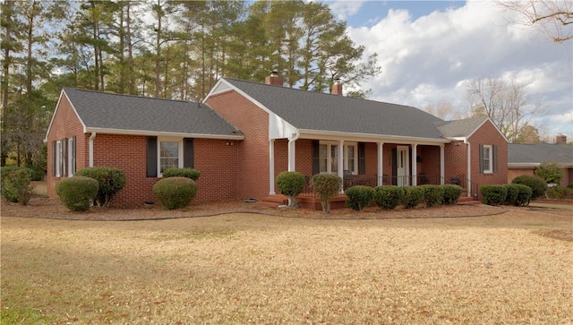 single story home featuring covered porch and a front lawn